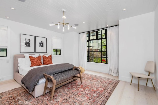 bedroom featuring a chandelier and light hardwood / wood-style flooring