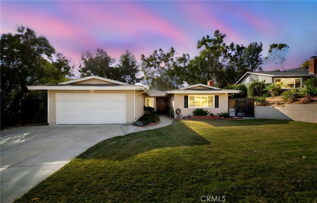 ranch-style home with a garage and a yard