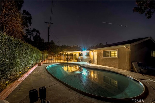 pool at twilight featuring a patio area