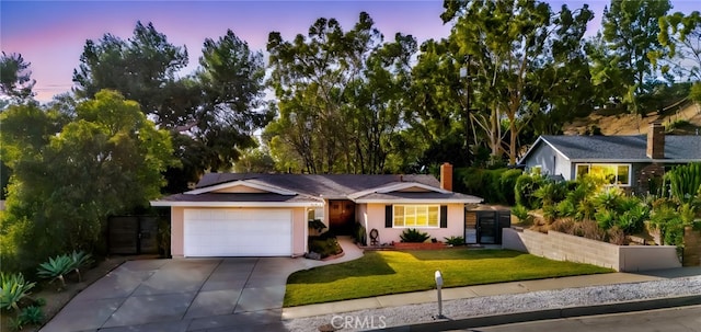 view of front facade featuring a garage and a lawn