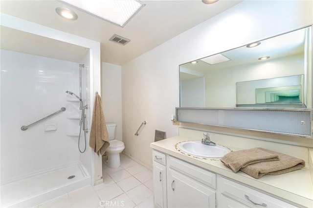 bathroom featuring tile patterned flooring, vanity, toilet, and walk in shower