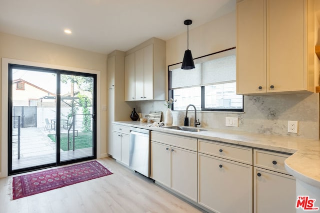 kitchen featuring pendant lighting, tasteful backsplash, sink, stainless steel dishwasher, and plenty of natural light