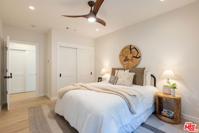 bedroom featuring ceiling fan, light wood-type flooring, and a closet