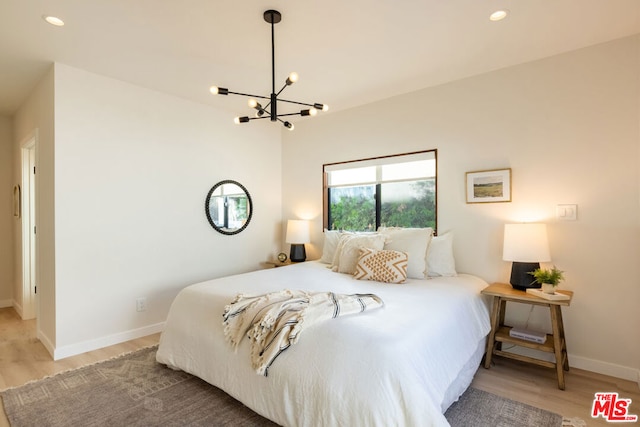 bedroom featuring a notable chandelier and light hardwood / wood-style floors