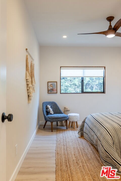 bedroom with ceiling fan and light hardwood / wood-style floors