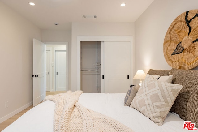 bedroom with a closet and light hardwood / wood-style flooring