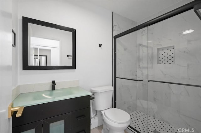 bathroom with toilet, walk in shower, and vanity