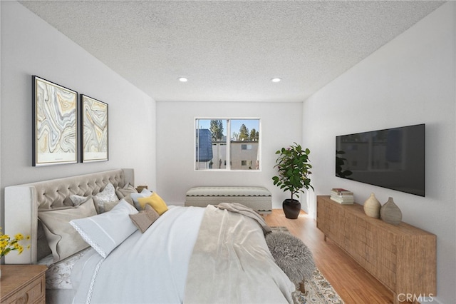 bedroom featuring light wood-type flooring and a textured ceiling