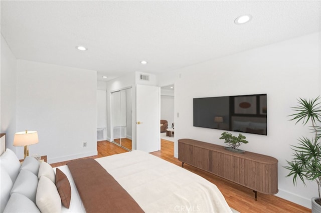 bedroom with a closet and light hardwood / wood-style floors