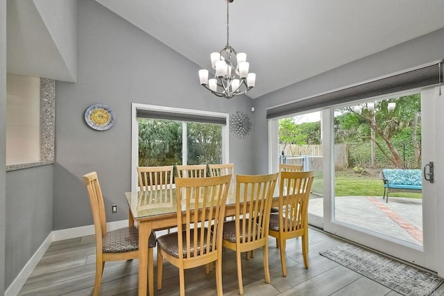 dining room featuring lofted ceiling, a notable chandelier, and light hardwood / wood-style floors