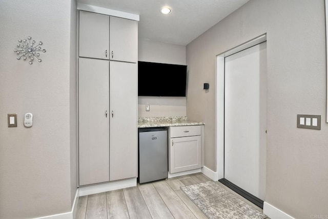 kitchen featuring refrigerator and gray cabinetry