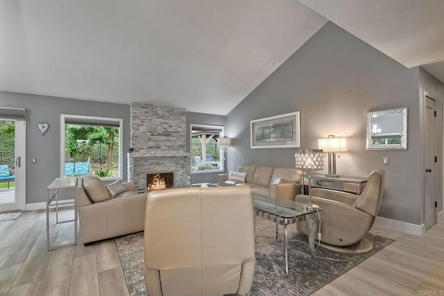 living room featuring lofted ceiling, a large fireplace, and light hardwood / wood-style flooring