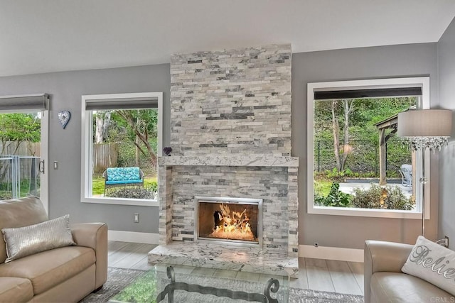 living room featuring light hardwood / wood-style flooring and a stone fireplace