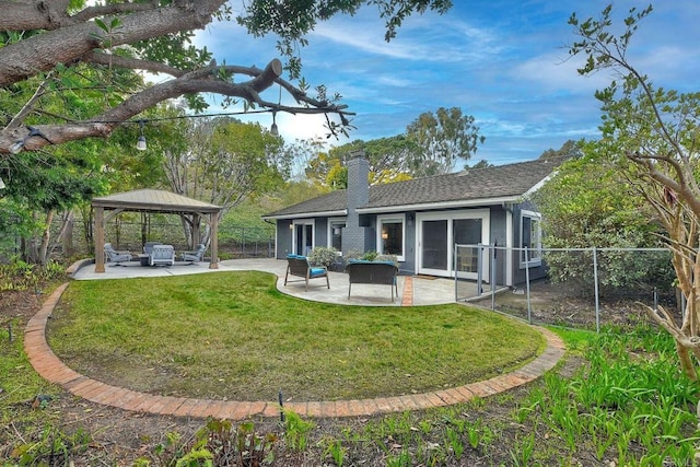 rear view of property with a gazebo, a patio, and a yard