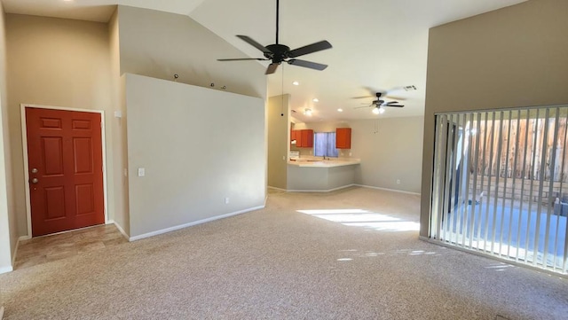 unfurnished living room featuring light carpet, ceiling fan, and high vaulted ceiling