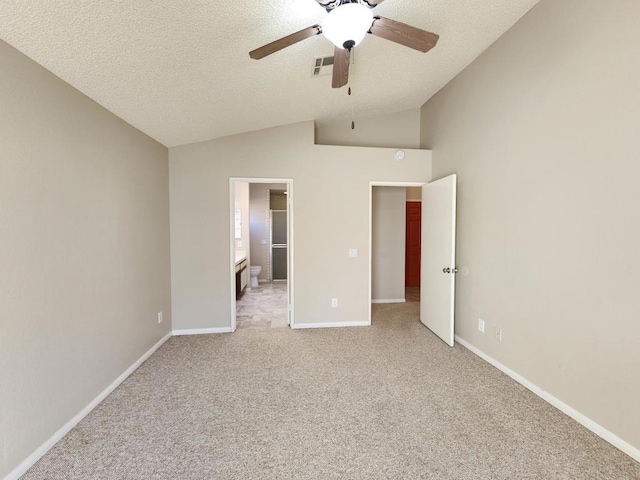 unfurnished bedroom with a textured ceiling, connected bathroom, light carpet, vaulted ceiling, and ceiling fan