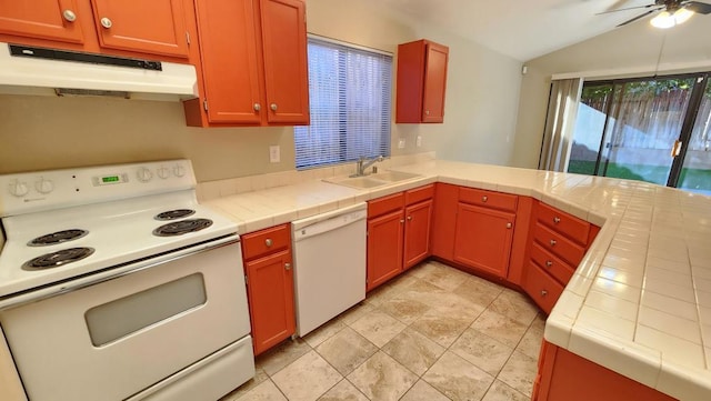 kitchen featuring lofted ceiling, tile countertops, sink, and white appliances