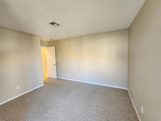 carpeted empty room with a textured ceiling