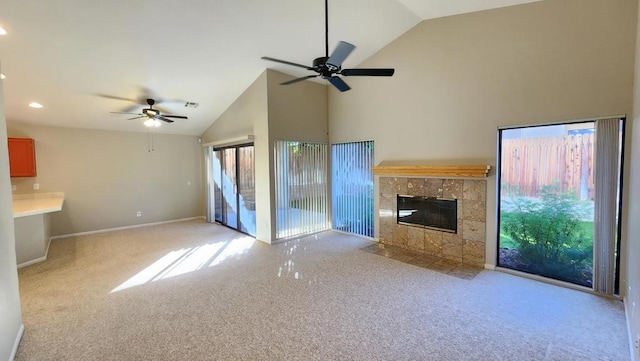 unfurnished living room with ceiling fan, high vaulted ceiling, light carpet, and a fireplace