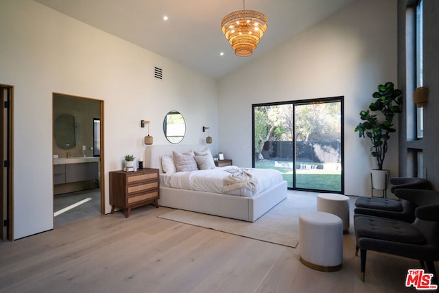 bedroom featuring a notable chandelier, ensuite bath, access to outside, light wood-type flooring, and high vaulted ceiling