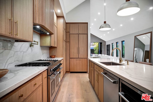 kitchen featuring stainless steel appliances, backsplash, hanging light fixtures, vaulted ceiling, and sink