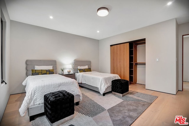 bedroom with a closet and light hardwood / wood-style floors