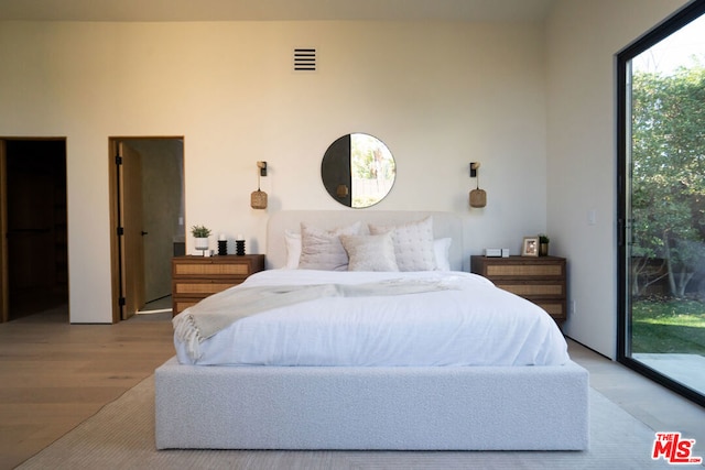 bedroom featuring access to exterior and light hardwood / wood-style flooring