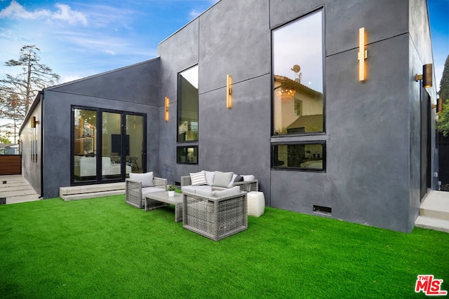 rear view of house with outdoor lounge area and a yard