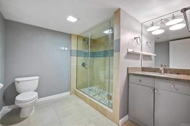 bathroom featuring toilet, tile patterned flooring, walk in shower, and vanity