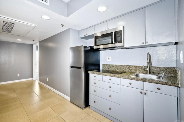 kitchen featuring light tile patterned flooring, appliances with stainless steel finishes, and sink