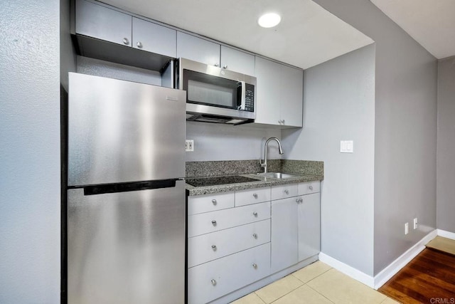 kitchen featuring sink, stainless steel appliances, and light tile patterned flooring