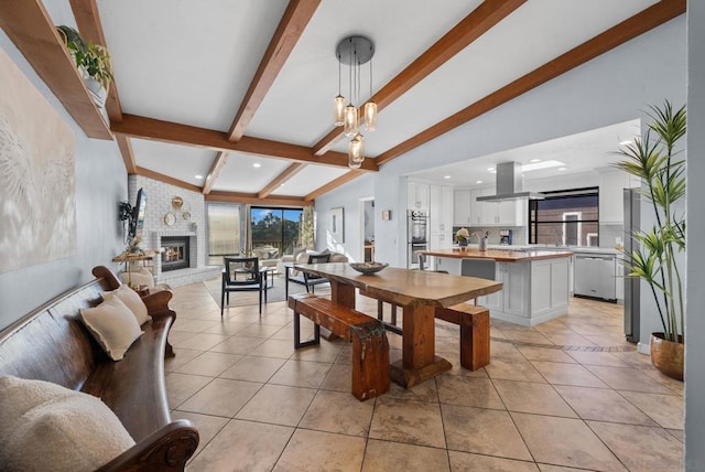 tiled dining room featuring a brick fireplace and vaulted ceiling with beams