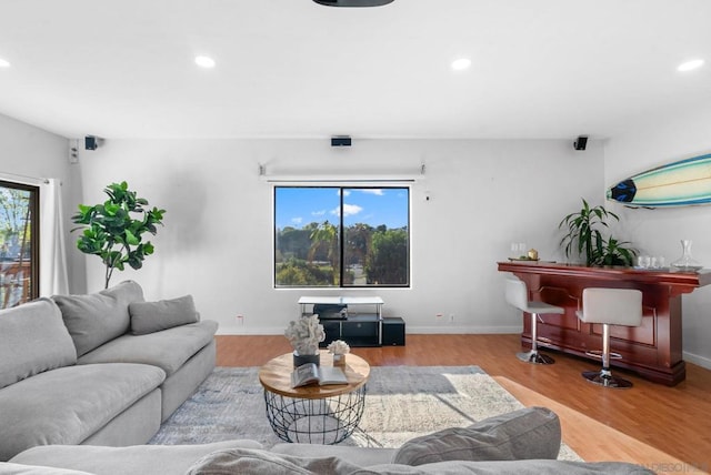 living room featuring bar area and light wood-type flooring