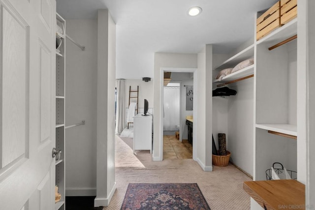 spacious closet with light carpet