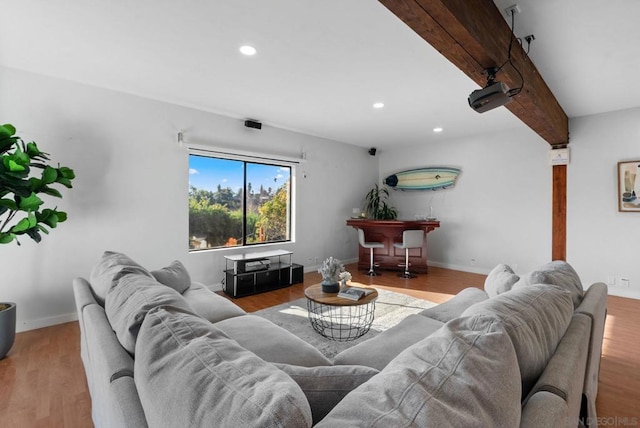 living room with light hardwood / wood-style flooring and beamed ceiling