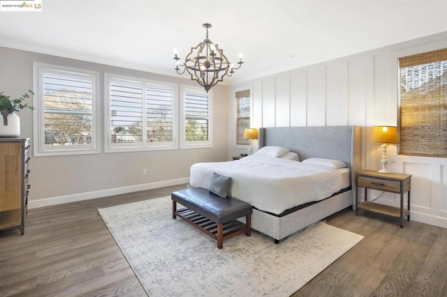 bedroom with dark hardwood / wood-style floors, an inviting chandelier, and multiple windows