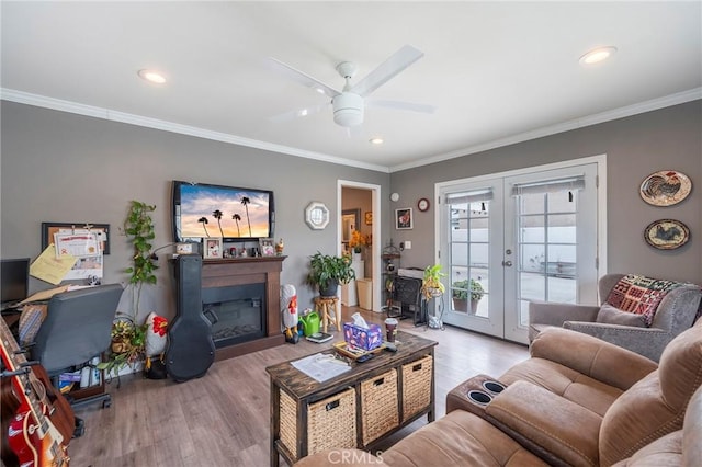 living room with light wood-type flooring, ceiling fan, ornamental molding, and french doors