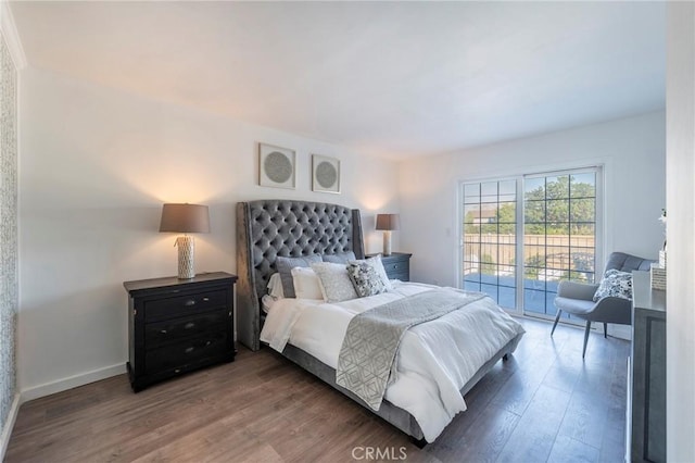 bedroom with access to exterior and dark hardwood / wood-style flooring