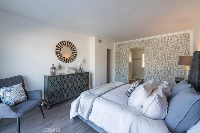 bedroom featuring wood-type flooring and ornamental molding