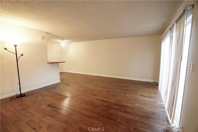 empty room featuring a textured ceiling and dark hardwood / wood-style floors