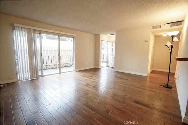 unfurnished room with dark wood-type flooring and a textured ceiling