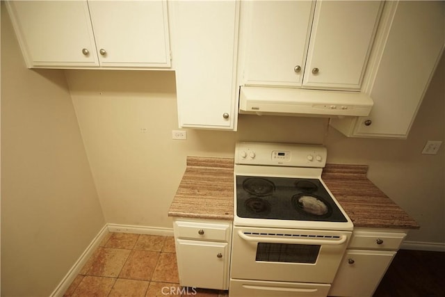 kitchen with light tile patterned floors, white cabinets, and white range with electric cooktop