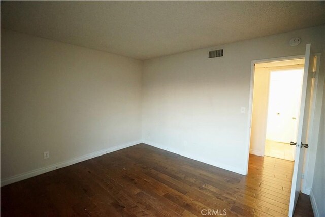 empty room with dark wood-type flooring