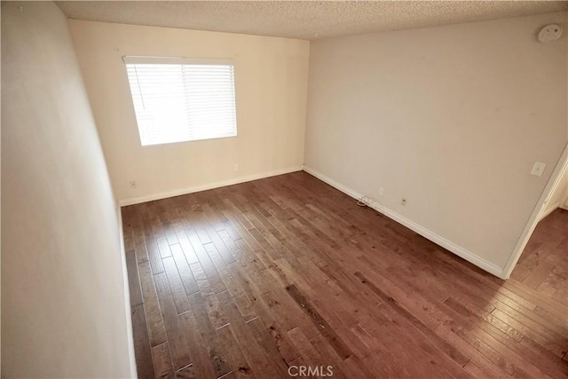 unfurnished room with dark hardwood / wood-style floors and a textured ceiling