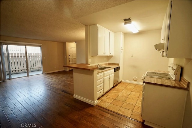 kitchen featuring stainless steel dishwasher, kitchen peninsula, sink, white cabinets, and ventilation hood