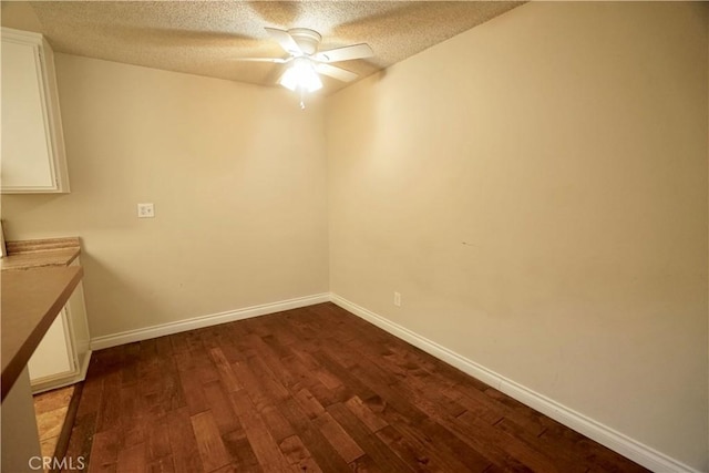 spare room with ceiling fan, a textured ceiling, and dark hardwood / wood-style floors