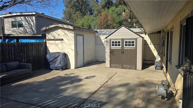 view of patio / terrace with an outdoor living space and a storage shed