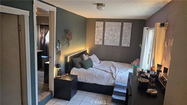 tiled bedroom featuring a textured ceiling