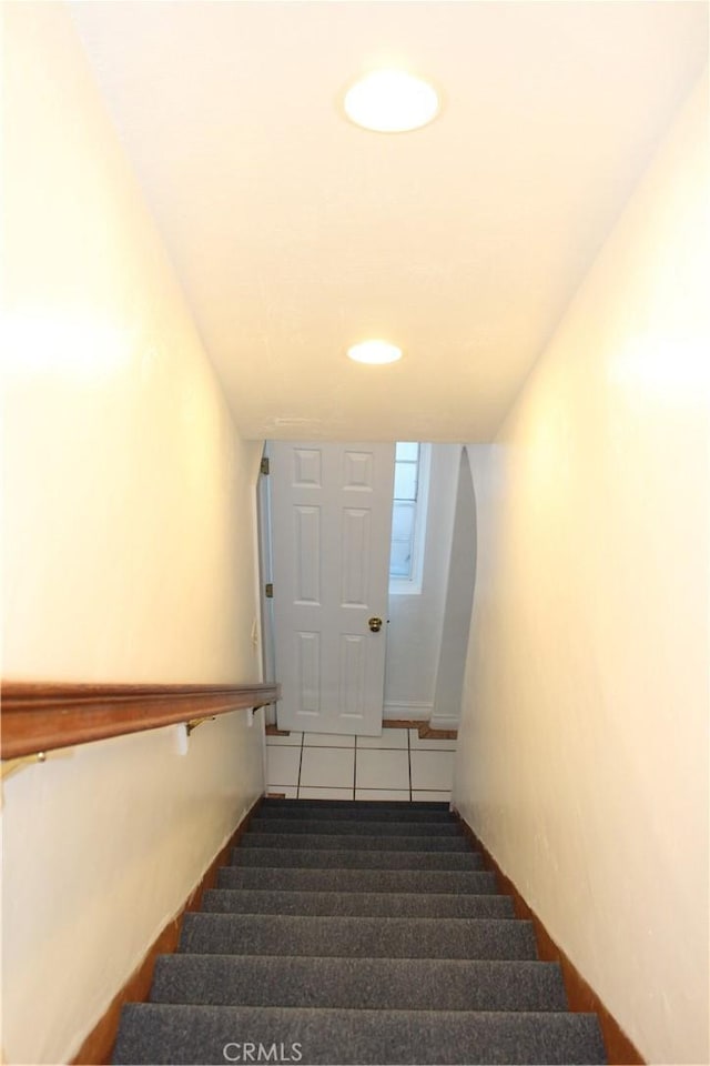 stairway with tile patterned floors