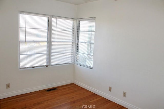 unfurnished room with hardwood / wood-style flooring